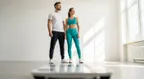 A fit woman confidently focusing on her strong reflection, demonstrating the importance of lean mass vs fat mass ratio over body weight.